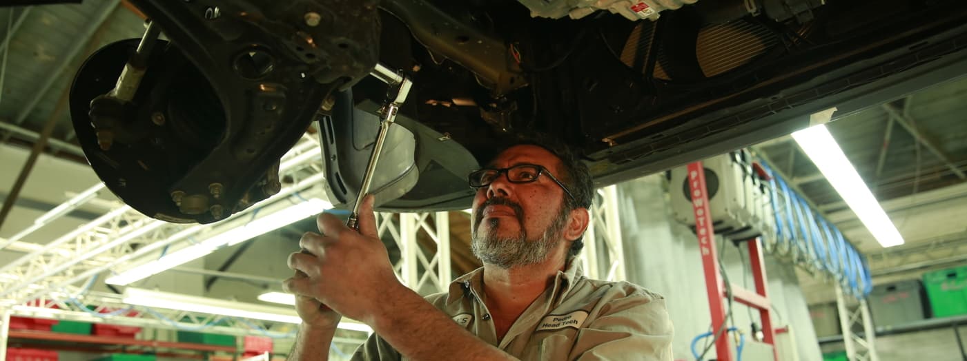 Eli's Collision Repair Center associate fixing vehicle